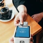 A card reader held out across a café table