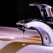 A tap dripping into a white sink