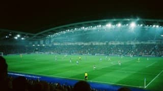 A football match in a floodlit stadium at night