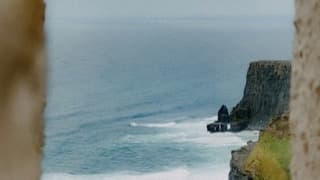 Cliffs above a rough blue sea, used as a series still