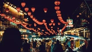 Food stalls under lanterns at night, used as a film still