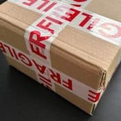 A cardboard parcel sealed with fragile tape