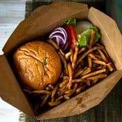 A burger and fries in a takeaway box